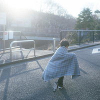 散歩道でブランケットを羽織る子ども、秋冬の防寒対策の写真