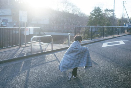 散歩道でブランケットを羽織る子ども、秋冬の防寒対策