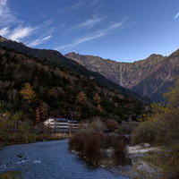 日暮れの上高地で焼岳を望む秋の山岳風景と清流の写真