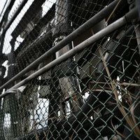 スチームパンク感ある線路脇の金網フェンスと進入禁止の景色の写真