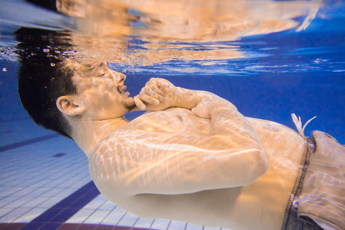 ぽっこりお腹を気にしてプールから出てこない男性