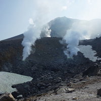 火口から噴煙を巻き上げる北海道の活火山・旭岳の山頂風景の写真
