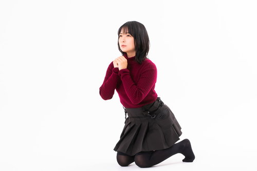 跪いて両手を合わせ懺悔する女性のポーズ・祈りの