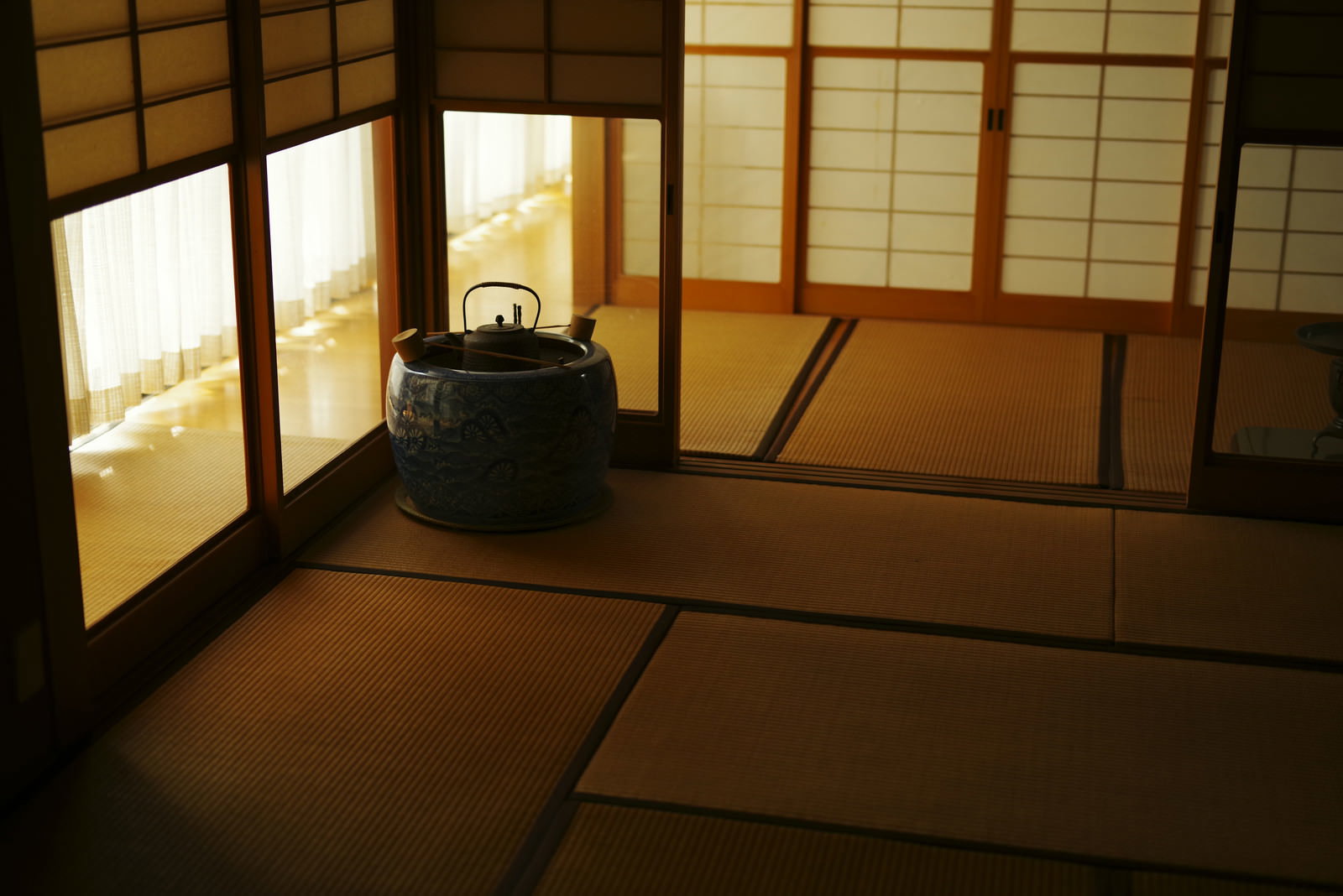 障子越しに夕日が差し込む畳敷きの和室