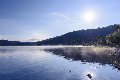 霧が立ち上がる尾瀬沼と燧ヶ岳の山並み、登山ハイキング風景
