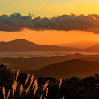 夕暮れに染まる田沢湖（秋田県仙北市）のオレンジ色の空と湖面の写真