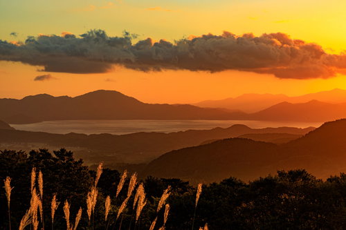 夕暮れに染まる田沢湖（秋田県仙北市）のオレンジ色の空と湖面