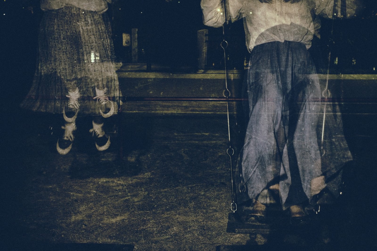 暗い公園で人の残像が見えるブランコの不気味な光景