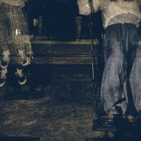 暗闇の公園で人の残像が見える揺れるブランコの写真