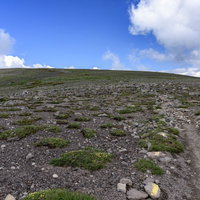 大雪山赤岳へと向かう石がちな稜線を歩く登山者の風景の写真
