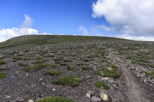 大雪山赤岳へと向かう石がちな稜線を歩く登山者の風景