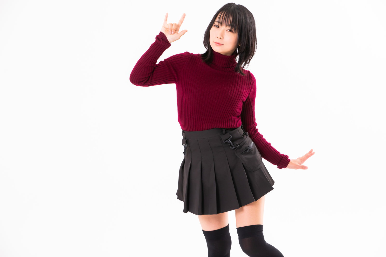 赤いタートルネックを着た女性がハンドサインでポーズ［モデル：にゃるる］