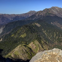 焼岳の山小屋と遠方の槍ヶ岳（やりがたけ）の山岳風景の写真