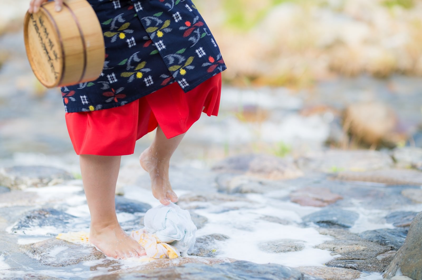 Bare feet treading laundry on stone path in traditional Japanese yukata