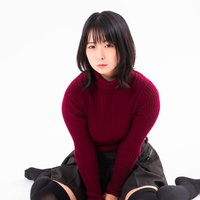 深い赤色のニットを着てペタンと床に座りこむ女性の写真
