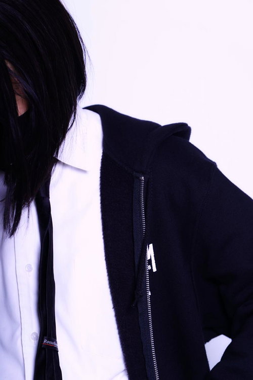 黒いパーカーを羽織ったワイシャツ姿の高校生の横顔