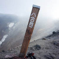 大雪山・旭岳8合目に立つ登山道の木碑と雲海の景色の写真