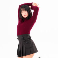 膝をついて両手を上に伸ばす背伸びをする女性の写真