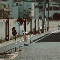 路上で項垂れる女子高生、グレーのパーカーを着た悩める学生の写真