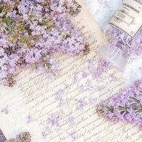 ライラックの花びらと白い便箋を使った春の雑貨の写真