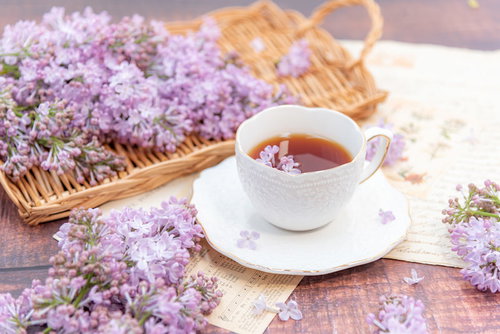 洋書に散らしたライラックとティーカップの紅茶
