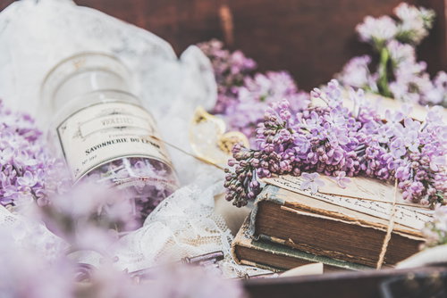 縛られた洋書の上に置いたライラックと香水瓶