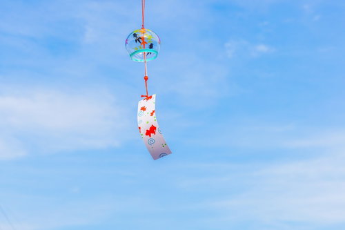夏の象徴、青空に揺れる風鈴と短冊の涼感を映した風情