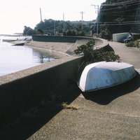 三浦半島の港町の道端に置かれた白いボートの写真