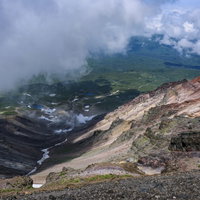 旭岳の爆裂火口から見下ろす雲海と火山地形の写真