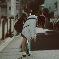 通学路で前屈みになる女子高生の写真