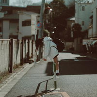 青春の疲れとともに歩む女子高生の通学路を自転車で往く日常の風景の写真