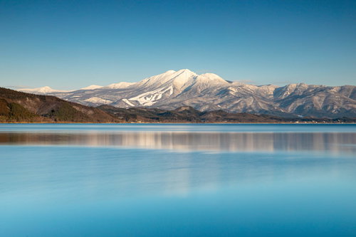 雪化粧の秋田駒ヶ岳と田沢湖に映る冬景色