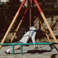 ブランコでうなだれるモチベーションが死んでる女子校生の写真