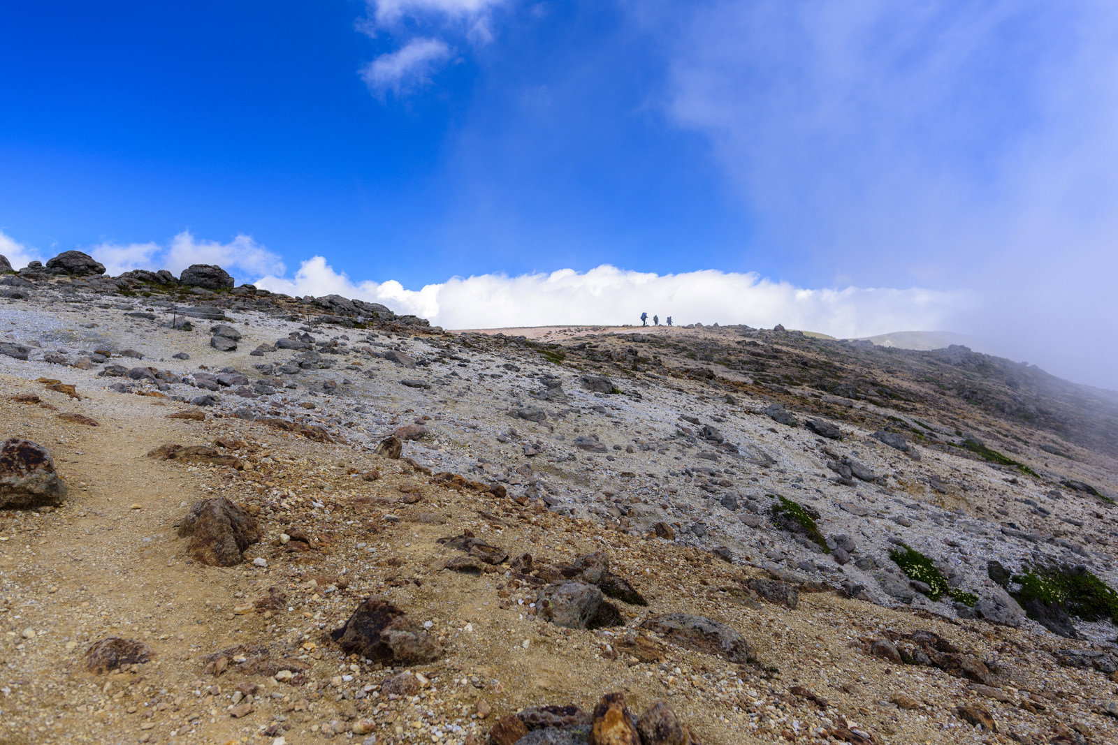 火山性の岩肌が特徴的な旭岳の斜面と青空