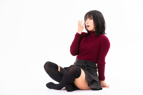 あぐらで座り込んであくびするモデル女性の疲労感あふれるポーズ