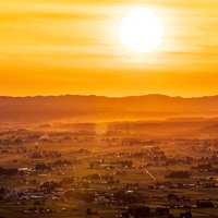 夕暮れの仙北平野とオレンジ色に染まる空と山並みの写真