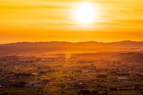夕暮れの仙北平野とオレンジ色に染まる空と山並み