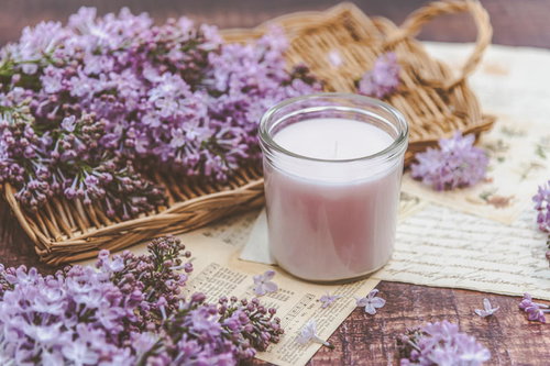 木製トレイに飾られた紫のライラックと白いキャンドル