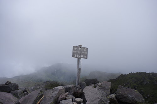 日光白根山山頂をガスが包む指導標の風景と岩場