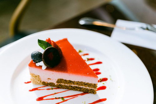 ピンク色のクリームとオレンジのゼリーが層状のケーキ