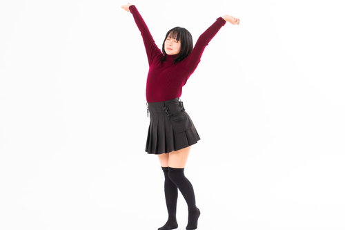 赤いトップスで全身を伸ばす女性の背伸び、朝のリフレッシュ