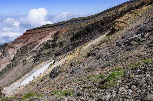 重なり合う地層が見える旭岳の爆裂火口の岩肌