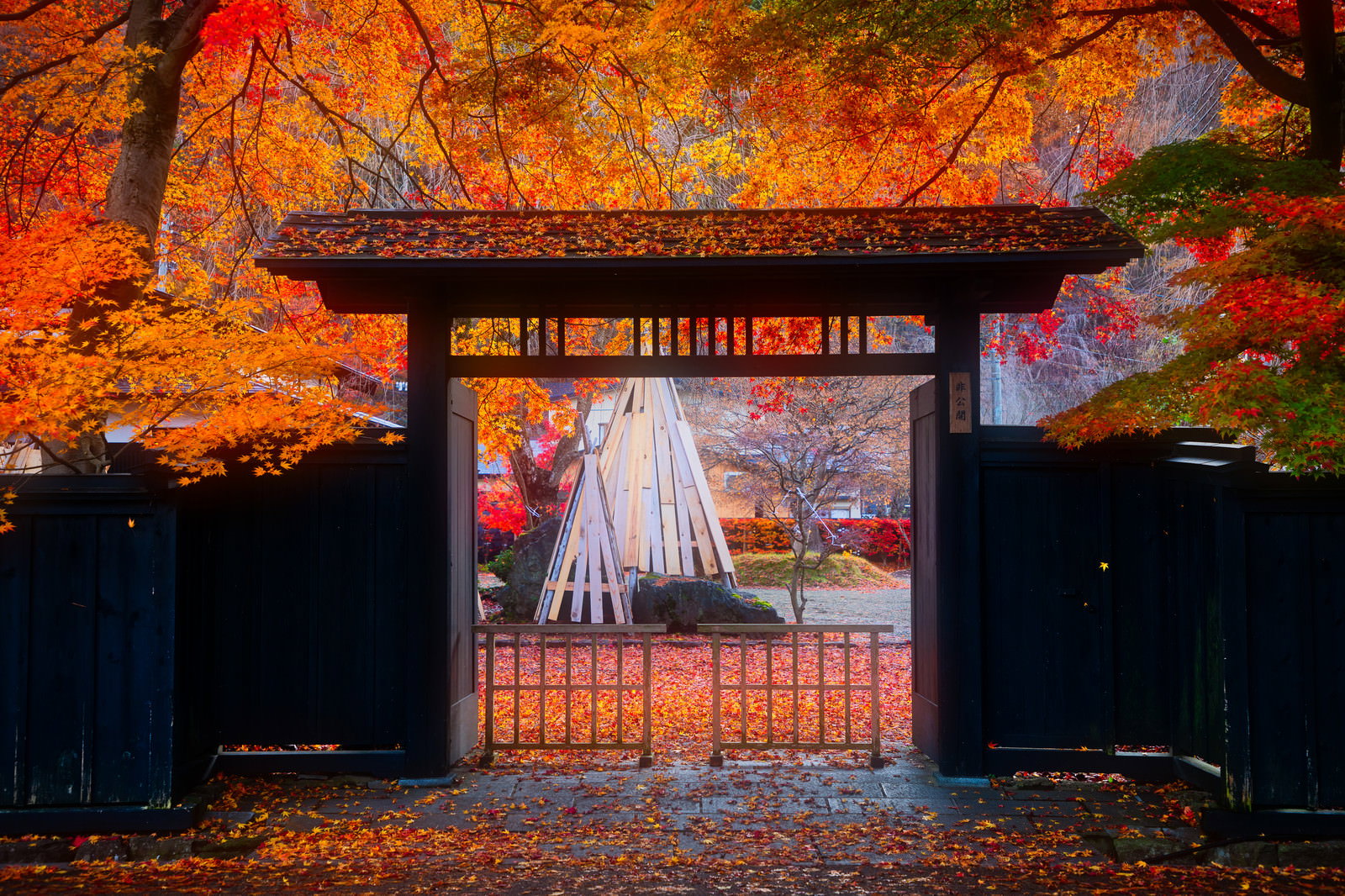 角館武家屋敷の黒い和風の門の前に散らばる紅葉した落葉
