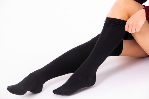 黒いニーハイソックスを履く女性の足元のファッション