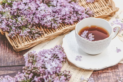 竹トレーに飾られたライラックとティーカップ