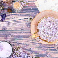 ライラックと香るハーブティーが置かれた机の写真