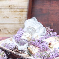 トランクケースに溢れるライラックと洋書、葉書の写真