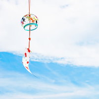 夏の風物詩、青空に揺れるカラフルな風鈴と短冊飾りの写真