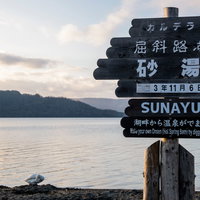 屈斜路湖・砂湯の案内看板と湖畔（北海道）の写真