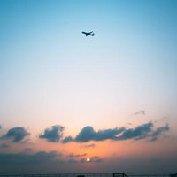 屋上から眺める夕焼け空と飛行機の風景の写真